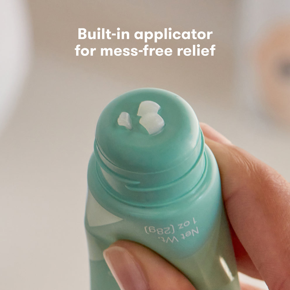 Hand holding a green bottle with a built-in applicator, text 'Built-in applicator for mess-free relief' on a neutral background.